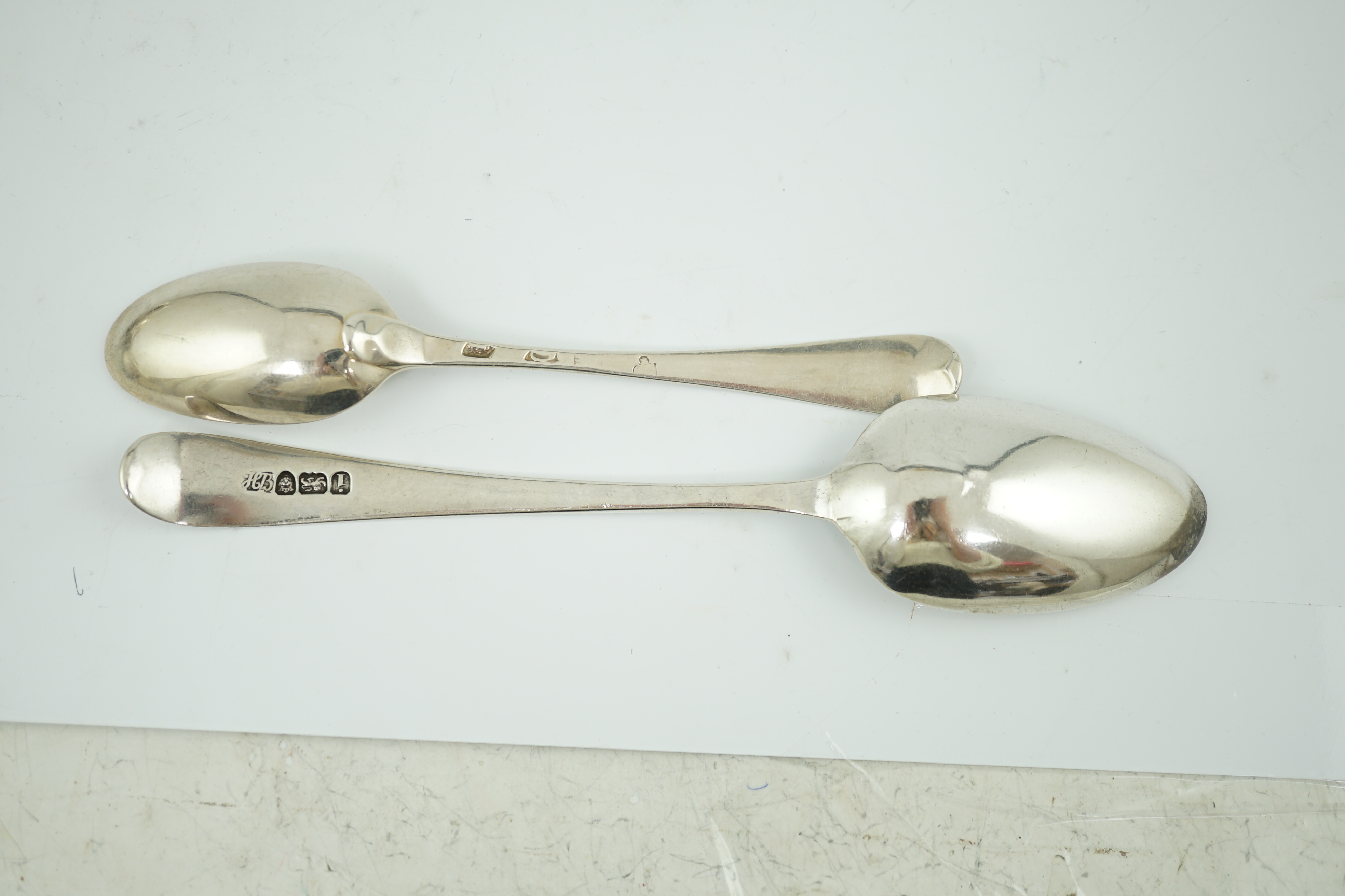 A set of nine George II silver Old English pattern dessert spoons, by George Hodges, London, 1731, together with four later spoons by Hester Bateman